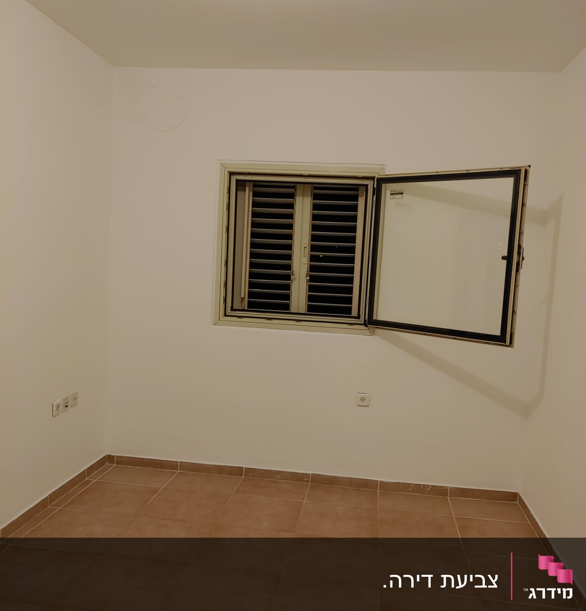 חדר עם קירות לבנים ורצפת אריחים חומים